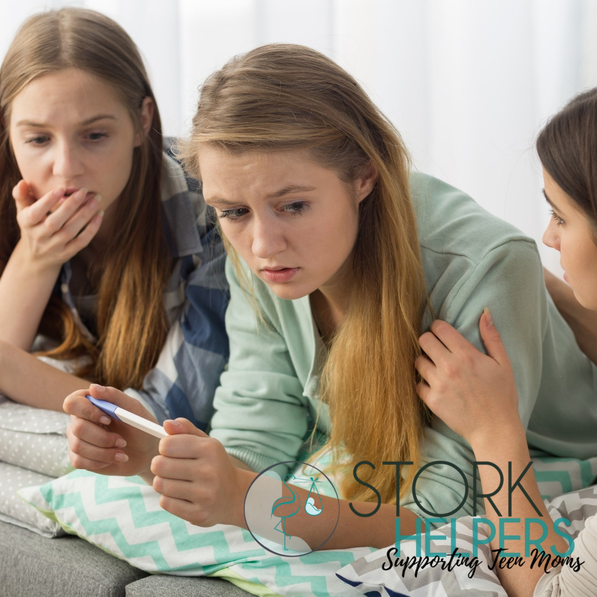 a teen girl with friends holding a pregnancy test